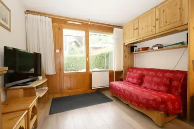 a living room with a red couch and a television at Résidence Le Prarion 2 C - Prarion 2 Bât A MAE-6413 in Les Houches