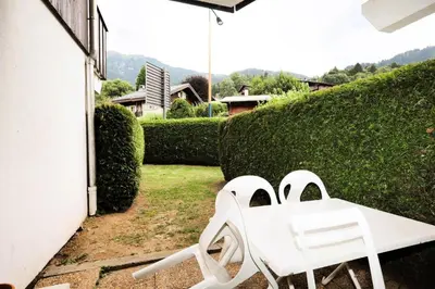 two white chairs sitting on the side of a house at Résidence Le Prarion 2 C - Prarion 2 Bât A MAE-6413 in Les Houches