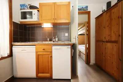 a small kitchen with a refrigerator and a bunk bed at Résidence Le Prarion 2 C - Prarion 2 Bât A MAE-6413 in Les Houches