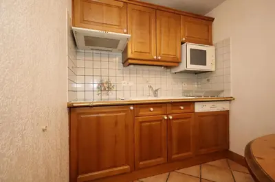 a kitchen with wooden cabinets and a microwave at Résidence Les Hauts De Chavants - Hauts de Chavants Berard 10 MAE-6415 in Les Houches