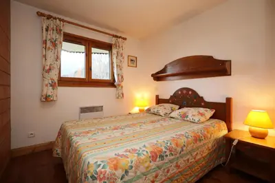 a bedroom with a bed with two lamps and a window at Résidence Les Hauts De Chavants - Hauts de Chavants Berard 10 MAE-6415 in Les Houches