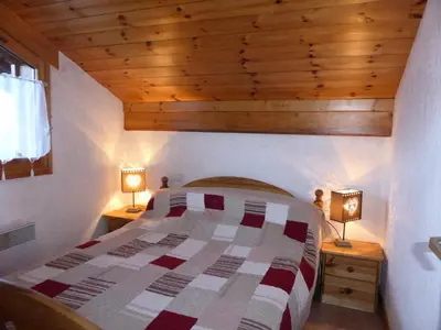 a bedroom with a bed and two lamps on tables at Chalets Alpages - Chalets Alpages 4 MAE-6417 in Les Houches