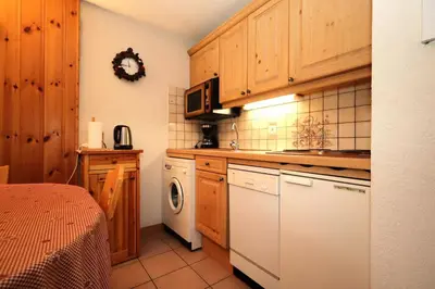 a kitchen with wooden cabinets and a washer and dryer at Résidence Les Aiguilles Rouges Bat B - Aiguilles Rouges B6 MAE-6418 in Les Houches