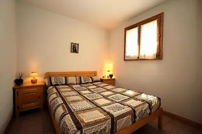 a bedroom with a bed with two night stands and a window at Résidence Les Aiguilles Rouges Bat B - Aiguilles Rouges B6 MAE-6418 in Les Houches
