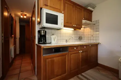 a small kitchen with a microwave and a sink at Résidence Les Hauts De Chavants - Hauts de Chavants Berard 01 MAE-6419 in Les Houches