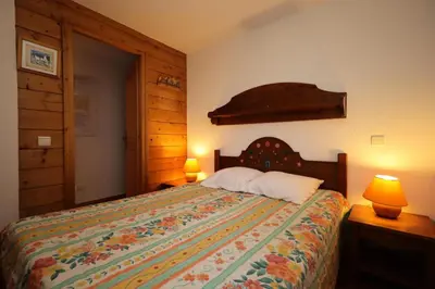 a bedroom with a bed with a colorful bedspread and two lamps at Résidence Les Hauts De Chavants - Hauts de Chavants Berard 01 MAE-6419 in Les Houches