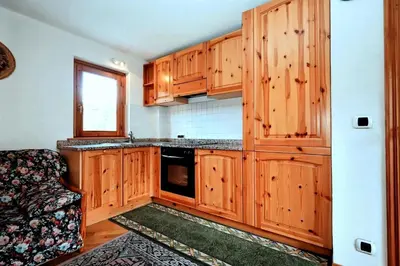 a kitchen with wooden cabinets and a black microwave at Résidence Beauregard - Beauregard 6 MAE-6421 in Les Houches