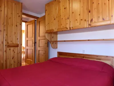 a bedroom with a bed and wooden cabinets at Résidence Beauregard - Beauregard 6 MAE-6421 in Les Houches