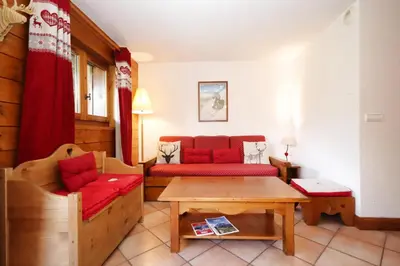 a living room with a red couch and a table at Résidence Les Hauts De Chavants - Hauts de Chavants Berard 04 MAE-6426 in Les Houches