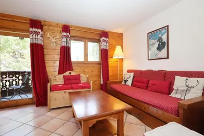 a living room with a red couch and a table at Résidence Les Hauts De Chavants - Hauts de Chavants Berard 04 MAE-6426 in Les Houches