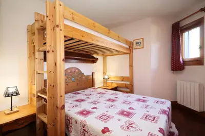 a bedroom with a wooden bunk bed with a bedspread at Résidence Les Hauts De Chavants - Hauts de Chavants Berard 04 MAE-6426 in Les Houches
