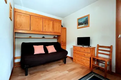 a bedroom with a black couch with two pink pillows at Résidence Le Prarion 2 C - Prarion 2 28 MAE-6429 in Les Houches