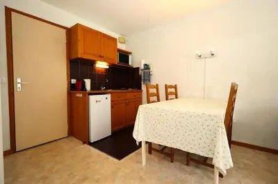 a kitchen with a table and a white refrigerator at Résidence Le Prarion 2 C - Prarion 2 C13 MAE-6430 in Les Houches