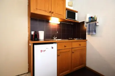 a kitchen with a white refrigerator and wooden cabinets at Résidence Le Prarion 2 C - Prarion 2 C13 MAE-6430 in Les Houches