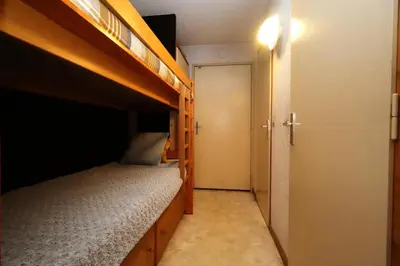 a small bedroom with two bunk beds and a door at Résidence Le Prarion 2 C - Prarion 2 C13 MAE-6430 in Les Houches