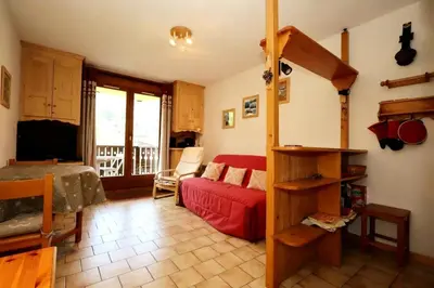 a living room with a red couch and a bed at Résidence Le ChÂteau Bruyeres - Château B42 MAE-6432 in Les Houches