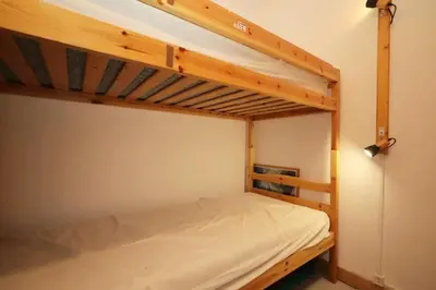a bedroom with two bunk beds with white sheets at Résidence Le ChÂteau Bruyeres - Château B42 MAE-6432 in Les Houches