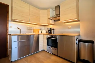 a kitchen with stainless steel appliances and wooden cabinets at Résidence Les Houches Villages - Houches Village B23 MAE-6424 in Les Houches