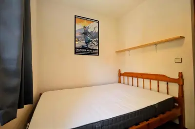 a bedroom with a bed with a poster on the wall at Résidence Les Houches Villages - Houches Village B23 MAE-6424 in Les Houches