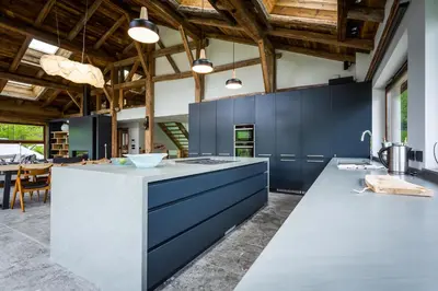 a kitchen with blue cabinets and a white island with bar stools at Chalet Léandre in Les Houches