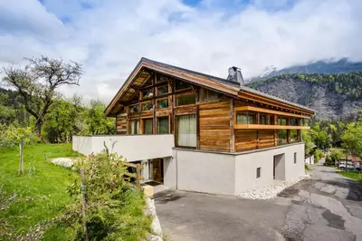 a house on a hill with a green yard at Chalet Léandre in Les Houches