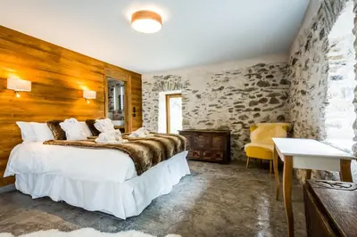 a bedroom with a large bed and a stone wall at Chalet Léandre in Les Houches