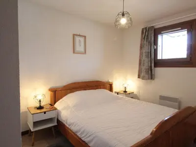 a bedroom with a bed and two tables with lamps at Appartement Central 6 Pers, Parking, Ascenseur, Proche Pistes et Commerces - FR-1-572-22 in Les Carroz d'Araches