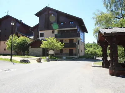 a large building with a tree in front of it at Appartement Central 6 Pers, Parking, Ascenseur, Proche Pistes et Commerces - FR-1-572-22 in Les Carroz d'Araches