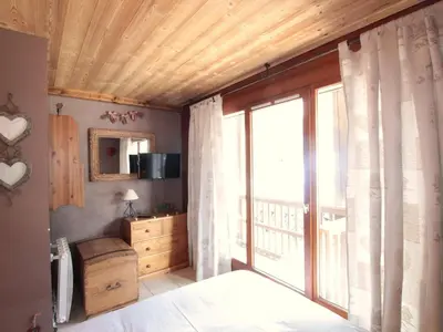 a bedroom with a large sliding glass door with a window at Appartement cosy 6 pers. au centre du village, proche des pistes et commerces - FR-1-572-52 in Les Carroz d'Araches