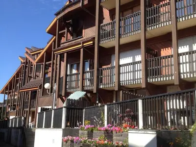 a large building with flowers in front of it at Appartement cosy 6 pers. au centre du village, proche des pistes et commerces - FR-1-572-52 in Les Carroz d'Araches
