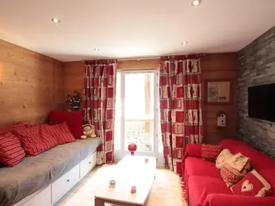 a living room with a red couch and a window at Appartement cosy 6 pers. au centre du village, proche des pistes et commerces - FR-1-572-52 in Les Carroz d'Araches