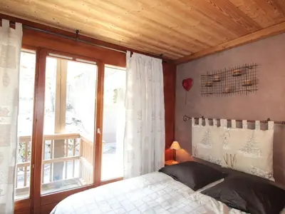 a bedroom with a bed and a large window at Appartement cosy 6 pers. au centre du village, proche des pistes et commerces - FR-1-572-52 in Les Carroz d'Araches