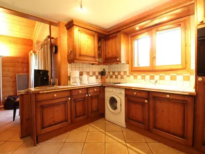 a kitchen with wooden cabinets and a washing machine at Duplex chaleureux 4 pièces avec wifi, parking, proche spa & bus pour ski - FR-1-572-43 in Les Carroz d'Araches