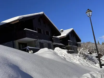 a pile of snow next to a building with a street light at 3 pièces cabine avec parking, près des pistes et commerces - FR-1-572-55 in Les Carroz d'Araches