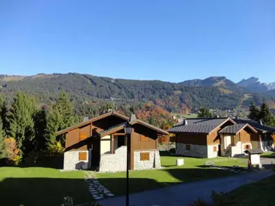 a group of houses with mountains in the background at 3 pièces cabine avec parking, près des pistes et commerces - FR-1-572-55 in Les Carroz d'Araches