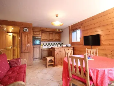 a living room with a table and a kitchen at 3 pièces cabine avec parking, près des pistes et commerces - FR-1-572-55 in Les Carroz d'Araches