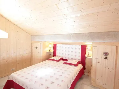 a bedroom with a bed with red and white sheets at Duplex 3 pièces pour 6 pers, centre-village, proche pistes et commerces - FR-1-572-78 in Les Carroz d'Araches