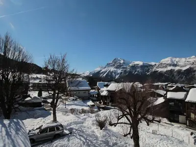 a snow covered city with mountains in the background at Duplex 3 pièces pour 6 pers, centre-village, proche pistes et commerces - FR-1-572-78 in Les Carroz d'Araches