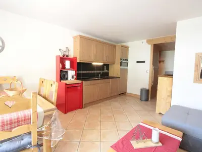 a kitchen with a red refrigerator and a table at Appartement cosy 4 pièces, 8 pers, garage, proche pistes et commerces - FR-1-572-73 in Les Carroz d'Araches