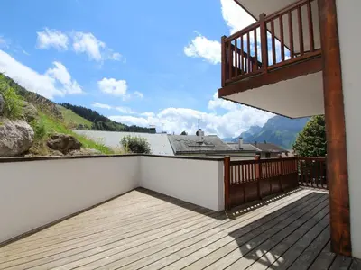 a balcony with a wooden deck with a view at Appartement cosy 4 pièces, 8 pers, garage, proche pistes et commerces - FR-1-572-73 in Les Carroz d'Araches