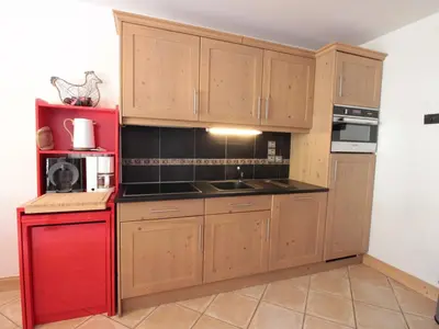 a kitchen with wooden cabinets and a red refrigerator at Appartement cosy 4 pièces, 8 pers, garage, proche pistes et commerces - FR-1-572-73 in Les Carroz d'Araches