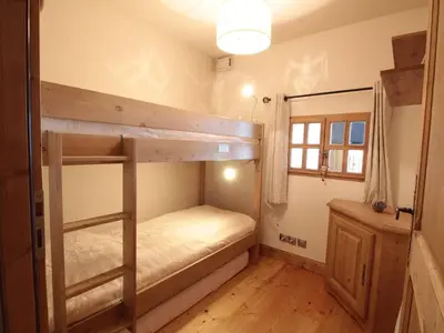 a room with two bunk beds and a mirror at Appartement cosy 4 pièces, 8 pers, garage, proche pistes et commerces - FR-1-572-73 in Les Carroz d'Araches