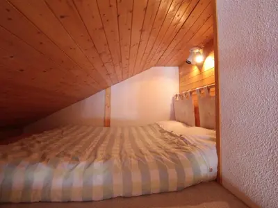 a bed in a room with a wooden ceiling at Appartement 8 pers, 4 pièces, 50m des pistes, parking, balcon, proche commerces - FR-1-572-88 in Les Carroz d'Araches
