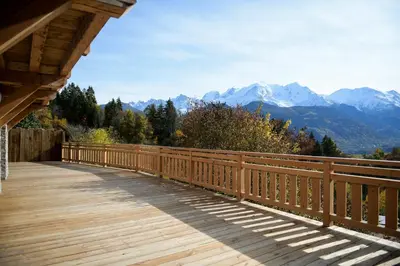 a wooden bridge with mountains in the background at Le Mazot d'la Marmotte Studio in Passy