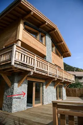 a house with a deck on the side of it at Le Mazot d'la Marmotte Studio in Passy