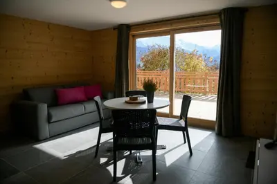 a living room with a table and a couch and a window at Le Mazot d'la Marmotte Studio in Passy