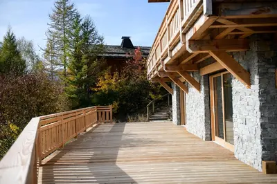 a wooden walkway next to a building with a wooden roof at Le Mazot d'la Marmotte Studio in Passy