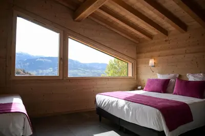 a bedroom with a bed and a large window at Le Mazot d'la Marmotte T3 in Passy