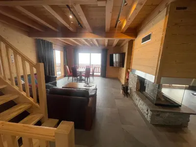 a wooden deck with a table and chairs and mountains at Le Mazot d'la Marmotte T3 in Passy