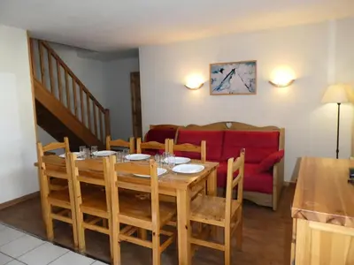 a dining room with a table and a red couch at Résidence Le Grand Panorama - Grand Panorama 514 MAE-5204 in Saint-Gervais-les-Bains